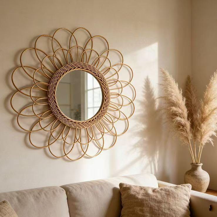 Sunburst rattan wall mirror with woven loop spokes above a sofa